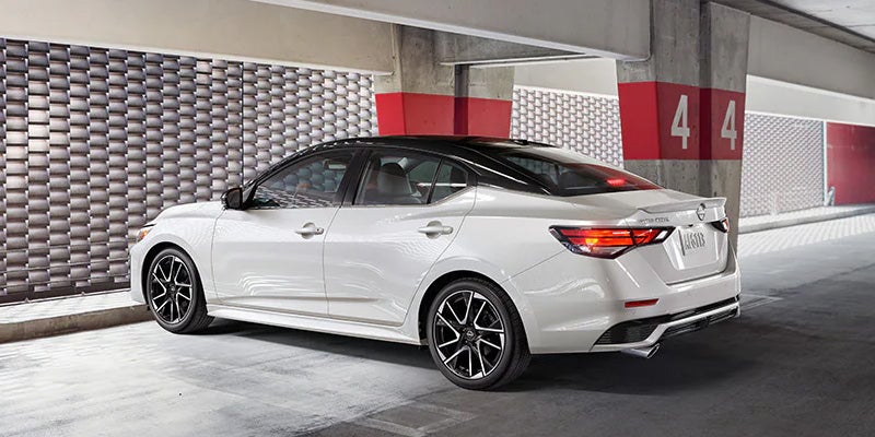 White Nissan Altima parked in a modern urban garage