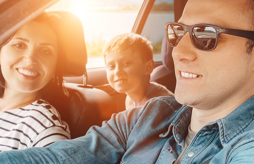 Smiling family inside a car enjoying a ride