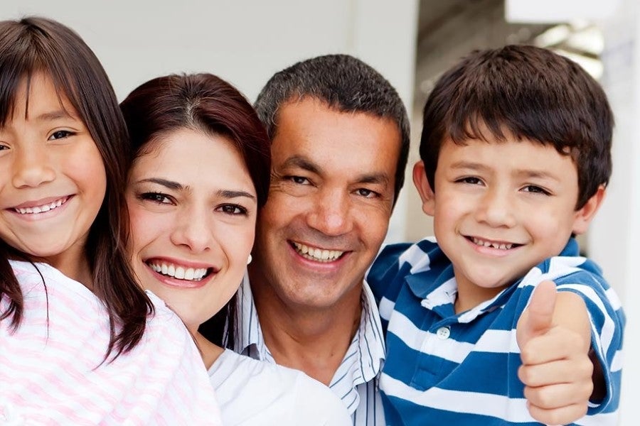 Smiling family of four posing together